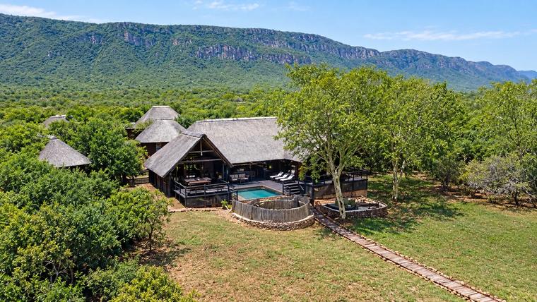 Aerial view of Kujabula Lodge, its pool and boma beneath the Lubombo Mountains
